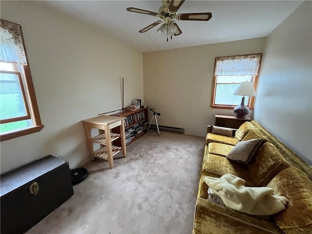 living area featuring carpet flooring, ceiling fan, plenty of natural light, and baseboard heating