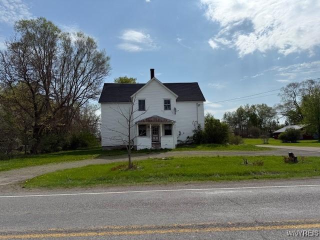 view of front of home featuring dirt driveway and a front yard