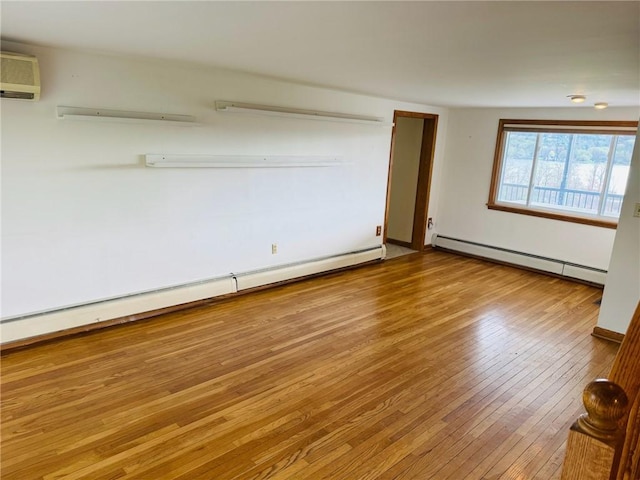 empty room with a baseboard radiator, a wall unit AC, and hardwood / wood-style floors