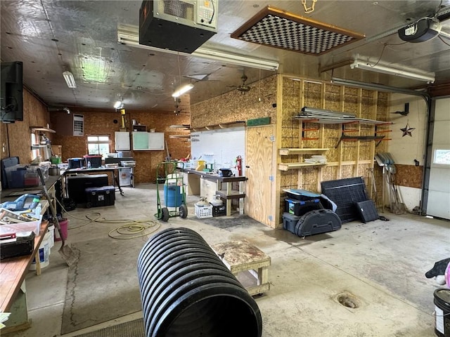 garage featuring a heating unit, a workshop area, and a garage door opener