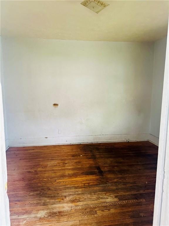 empty room with baseboards and wood finished floors