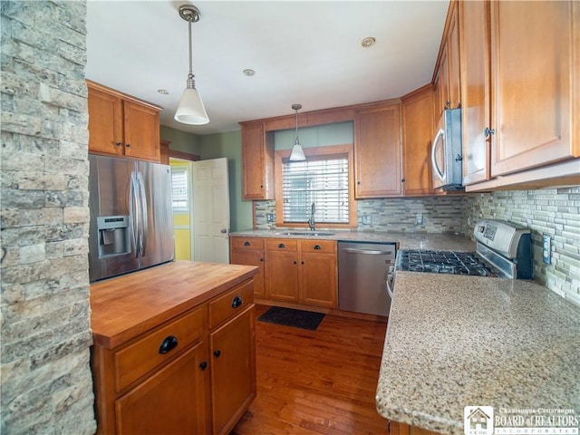 53 W 5th St, Dunkirk-City, NY 14048 - kitchen with brown cabinetry, dark wood-type flooring, tasteful backsplash, a sink, and stainless steel appliances