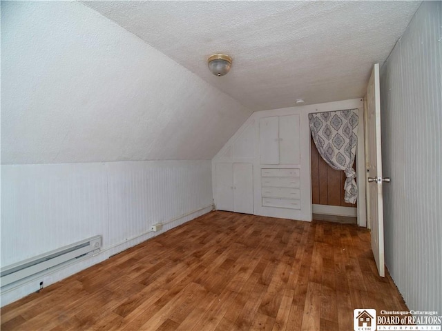 53 W 5th St, Dunkirk-City, NY 14048 - bonus room featuring a baseboard radiator, wood-type flooring, vaulted ceiling, and a textured ceiling