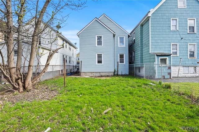 back of house with a lawn and a fenced backyard