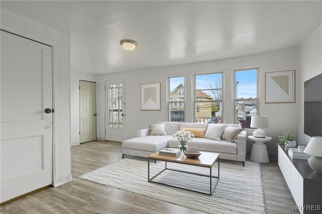 living room with baseboards and light wood finished floors