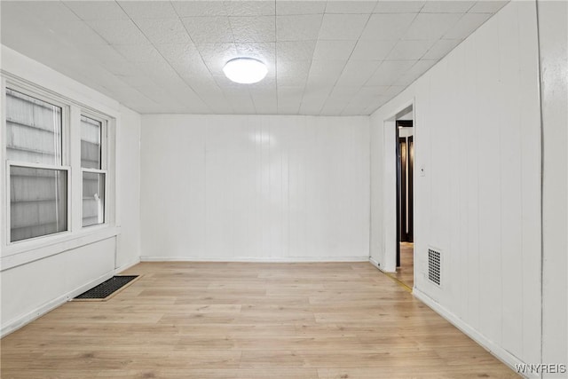 unfurnished room featuring light wood-style flooring and visible vents