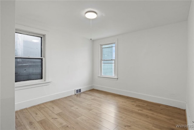 unfurnished room with baseboards, visible vents, and light wood-style floors