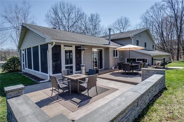 back of house with outdoor dining area, roof with shingles, a sunroom, a patio area, and a yard