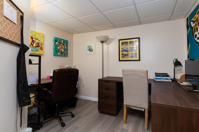 office with baseboards, a paneled ceiling, and wood finished floors