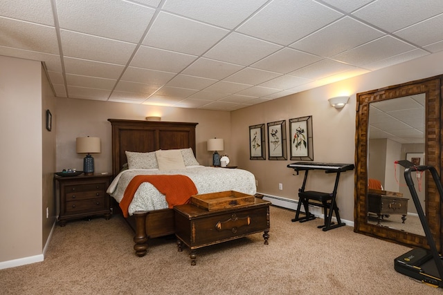 bedroom with baseboards, a paneled ceiling, baseboard heating, and light carpet