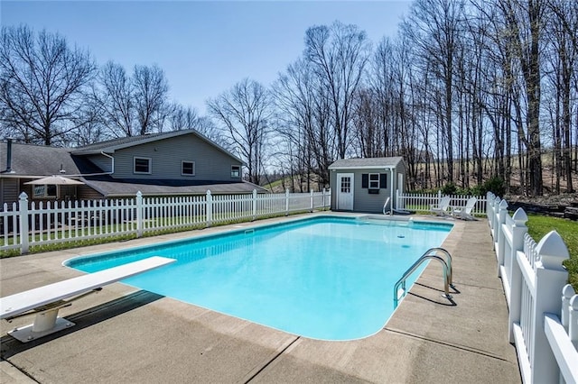 view of swimming pool with a fenced in pool, a diving board, and a patio