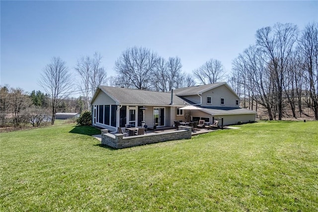 back of house featuring roof with shingles, a yard, a sunroom, and a patio area