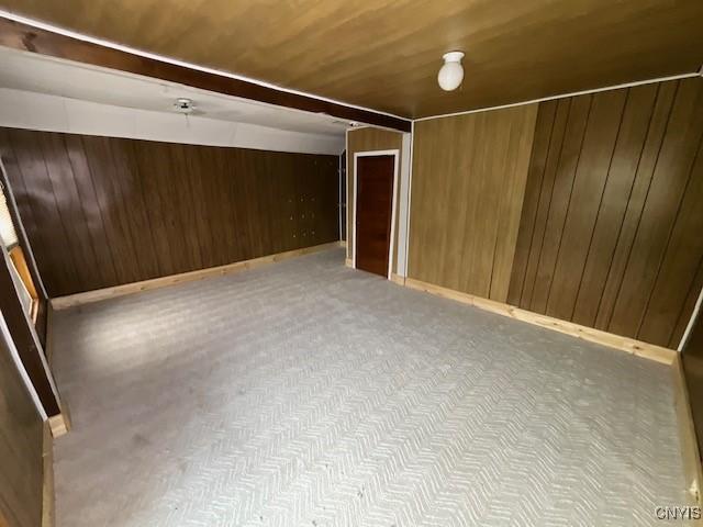 bonus room with wood walls and wooden ceiling