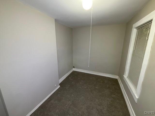 carpeted empty room featuring baseboards