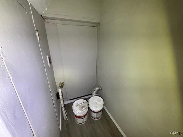laundry area featuring baseboards and wood finished floors