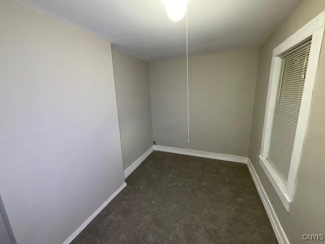 carpeted empty room featuring baseboards