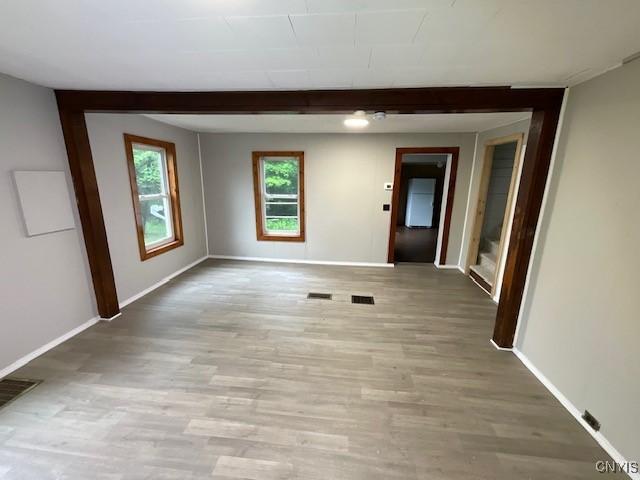 empty room with baseboards, light wood-style floors, and visible vents