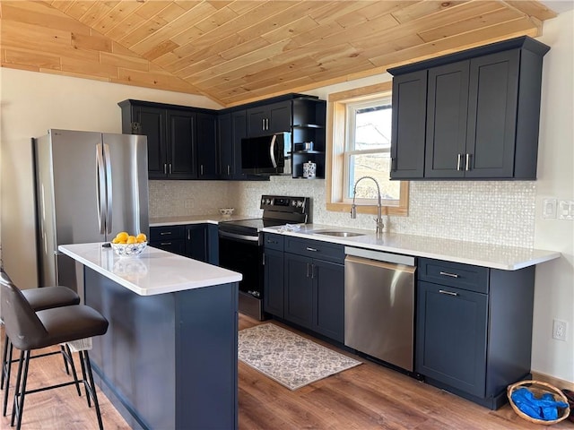 kitchen with a kitchen breakfast bar, vaulted ceiling, a sink, wooden ceiling, and stainless steel appliances