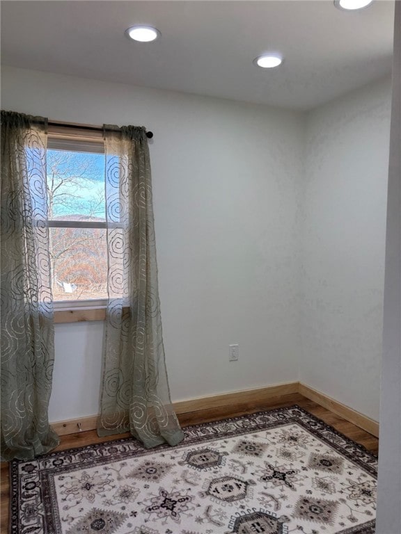 unfurnished room featuring baseboards, recessed lighting, and wood finished floors