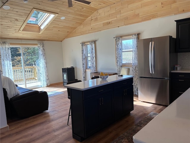 kitchen with dark cabinetry, freestanding refrigerator, and wood ceiling