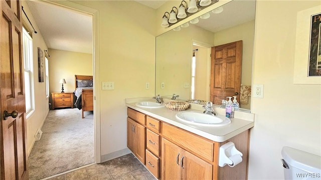 bathroom with double vanity, toilet, a sink, and ensuite bath