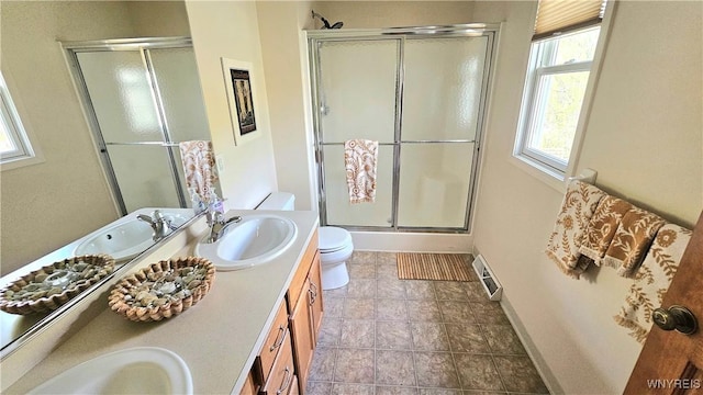 full bath featuring toilet, a shower stall, and a sink