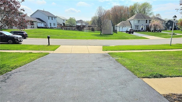 view of road featuring a residential view and concrete driveway