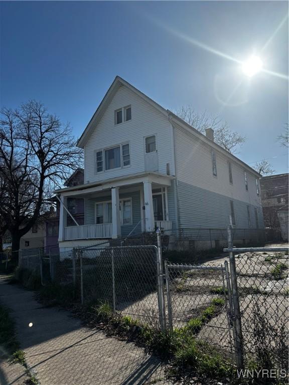 66 W Parade Ave, Buffalo, NY 14208 - view of front of house with a porch, a gate, a fenced front yard, and a chimney