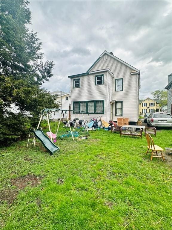 rear view of property with a lawn