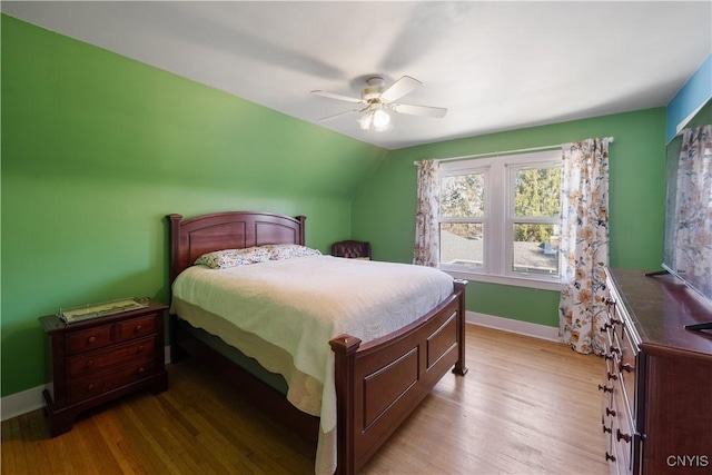 bedroom with baseboards, ceiling fan, light wood-type flooring, and lofted ceiling