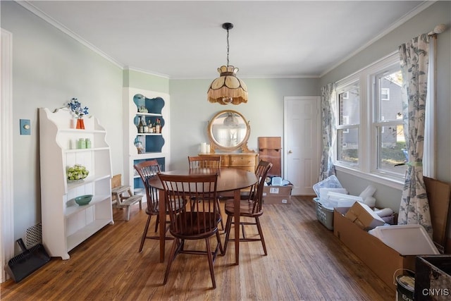 dining area featuring ornamental molding and wood finished floors