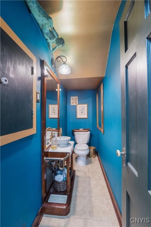 bathroom featuring visible vents, vanity, tile patterned floors, baseboards, and toilet