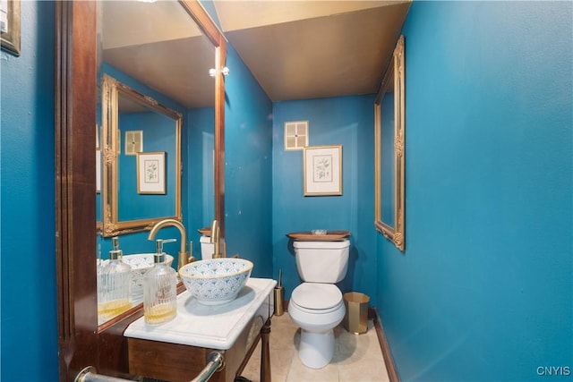 half bath with toilet, visible vents, tile patterned flooring, and vanity