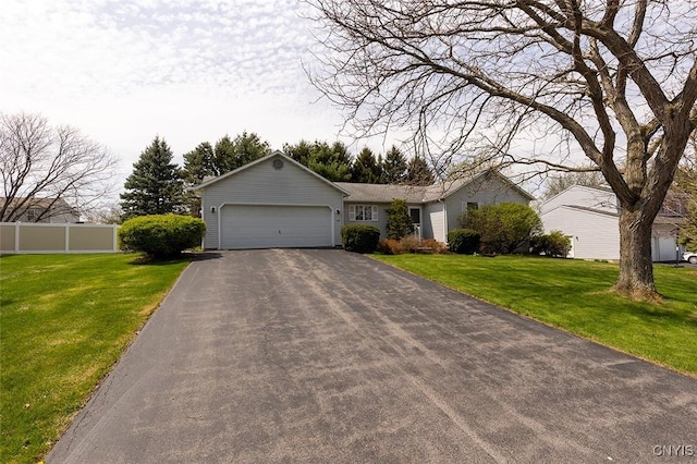 ranch-style house featuring fence, aphalt driveway, a front lawn, and a garage