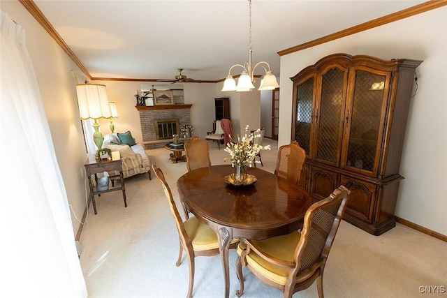 dining room with ceiling fan, light colored carpet, crown molding, a fireplace, and baseboards