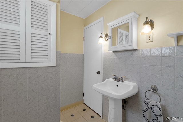 bathroom featuring tile walls, tile patterned flooring, and a wainscoted wall