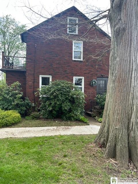 4 Brewer Pl, Westfield, NY 14787 - view of side of property featuring a lawn and brick siding