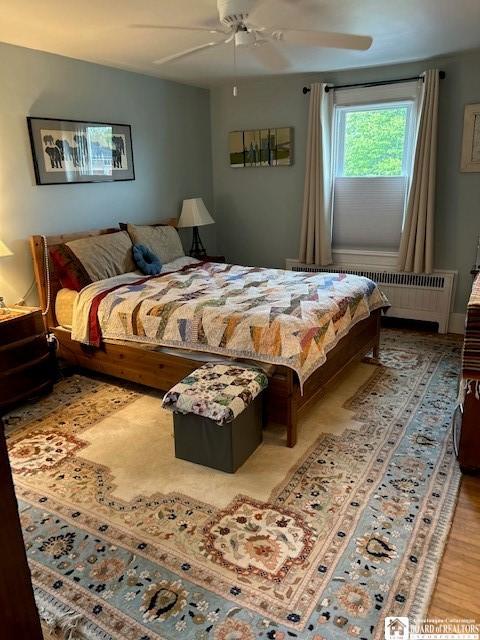 4 Brewer Pl, Westfield, NY 14787 - bedroom featuring wood finished floors, a ceiling fan, and radiator heating unit