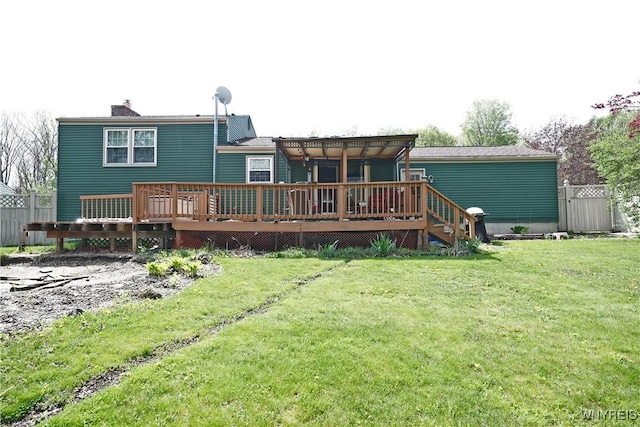 back of house with a chimney, a yard, and a deck