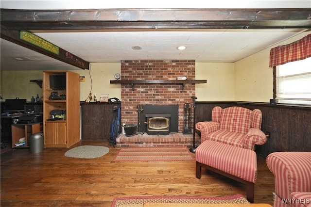 living area featuring wainscoting, wood finished floors, and a fireplace
