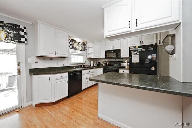 kitchen featuring a sink, dark countertops, black appliances, and white cabinetry