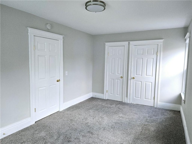 unfurnished bedroom with baseboards and carpet