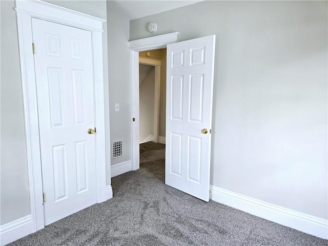 unfurnished bedroom with visible vents, carpet flooring, and baseboards