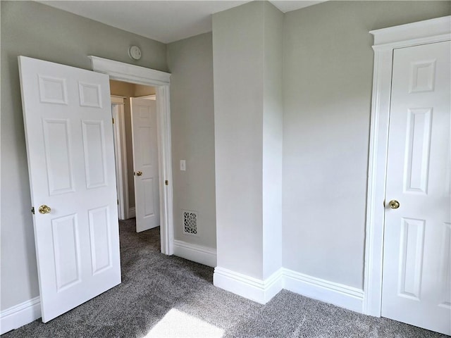 unfurnished bedroom featuring baseboards, carpet flooring, and visible vents