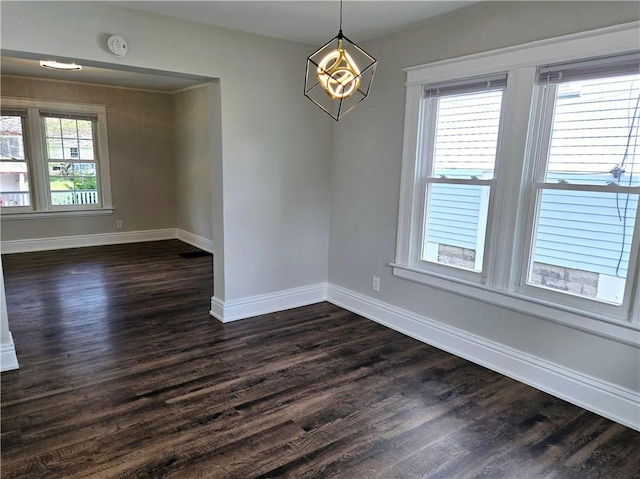 unfurnished dining area with baseboards and dark wood finished floors