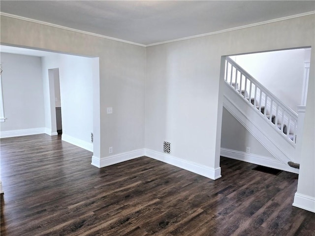 empty room with ornamental molding, baseboards, visible vents, dark wood-style floors, and stairway