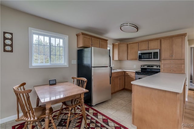 kitchen featuring light countertops, stainless steel appliances, and a sink