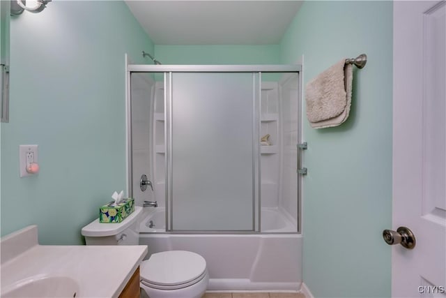 full bathroom with vanity, combined bath / shower with glass door, tile patterned floors, and toilet