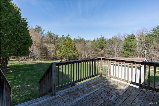 wooden deck featuring a lawn