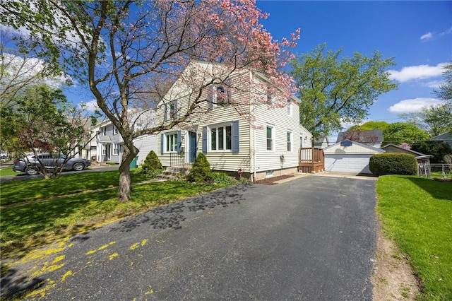 view of front of property with a detached garage and a front lawn